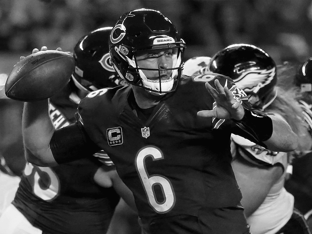 High-contrast black-and-white action photograph of a Chicago Bears quarterback cocking his arm to throw during an NFL game